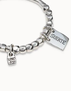 Beaded stretch bracelet with tubular piece and a charm