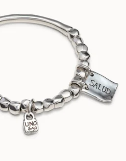 Beaded stretch bracelet with tubular piece and charms